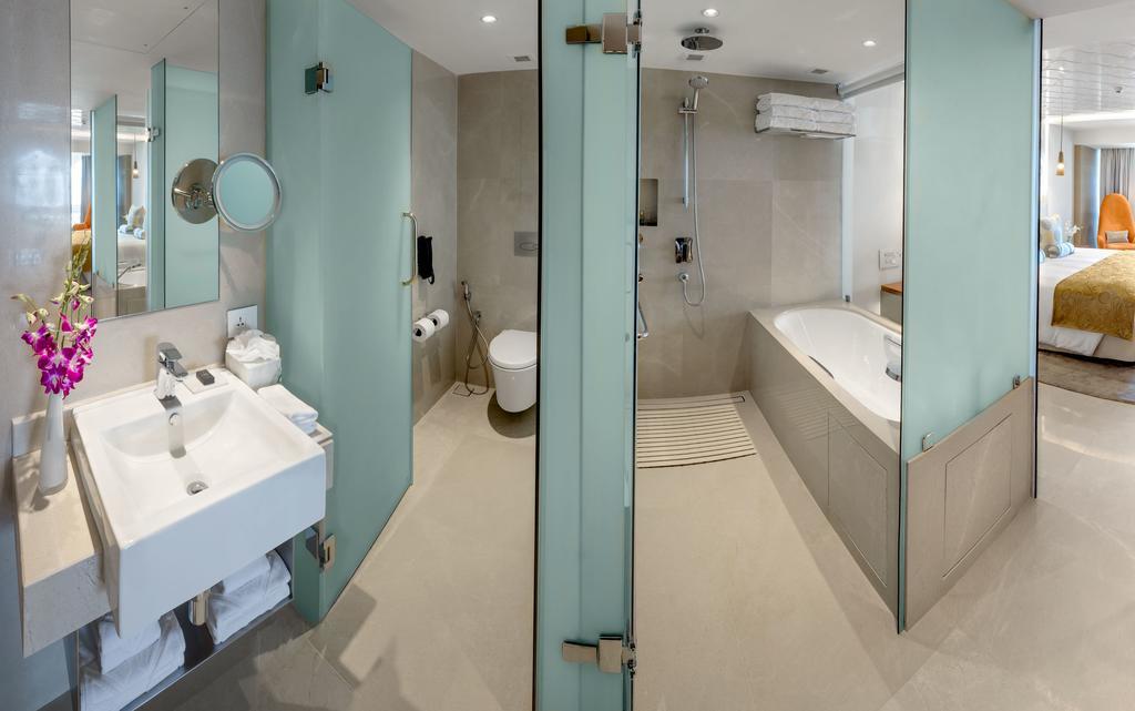 فندق ذا تاج محل تاور مومباي المظهر الخارجي الصورة The photo shows a modern bathroom with a sleek design. To the left, there is a sink with a mirror above it, and beneath the sink, there are some storage shelves. The area also features a glass partition leading to a shower. On the right side, there i