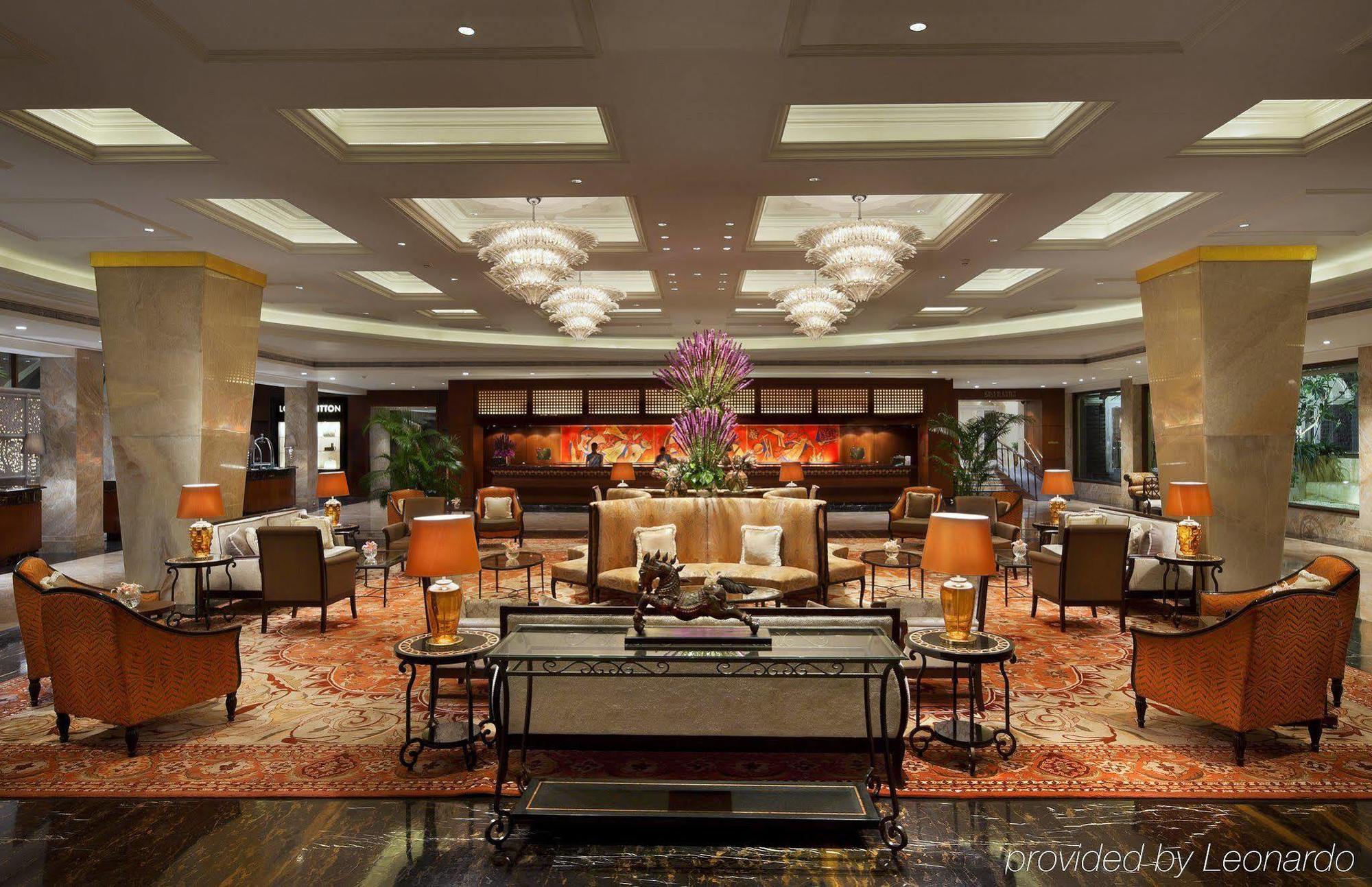 فندق ذا تاج محل تاور مومباي المظهر الخارجي الصورة The photo shows an elegant hotel lobby. It features a spacious area with plush seating, including stylish armchairs and sofas arranged around coffee tables. Central to the space is a large flower arrangement, adding a touch of color and sophisticatio
